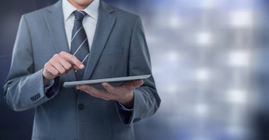 İşadamı holding tablet gri ışıklar arka plan ile