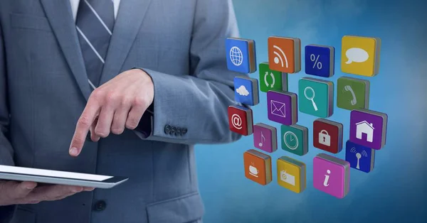 Businessman holding tablet with apps icons with blue foggy background — Stock Photo, Image