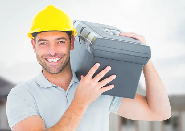 Trabalhador da construção com caixa de ferramentas na frente do canteiro de obras — Fotografia de Stock