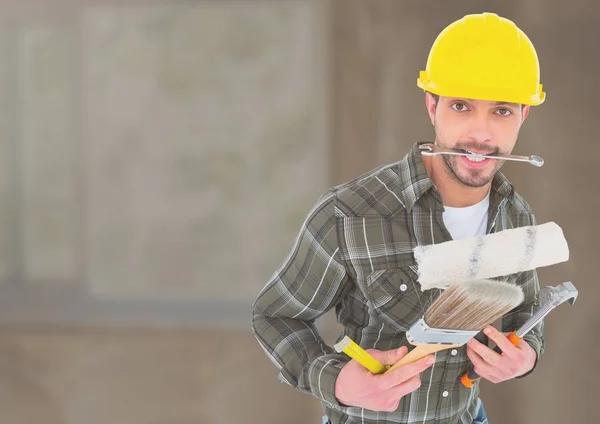 Trabajador de la construcción con herramientas en frente de la obra — Foto de Stock