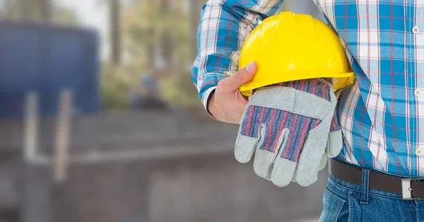 Operaio edile con guanti di sicurezza e cappello davanti al cantiere — Foto Stock