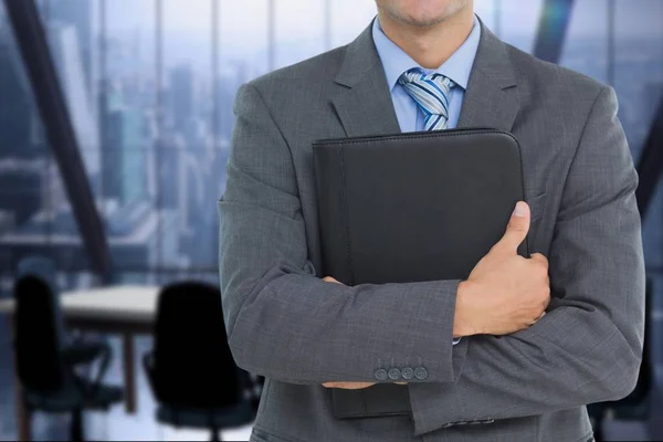 Hombre de negocios sosteniendo un cuaderno contra fondo de oficina —  Fotos de Stock