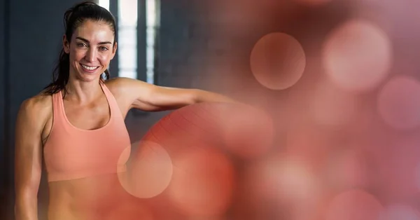 Женщина с мячом для йоги и переходом на красный боке — стоковое фото