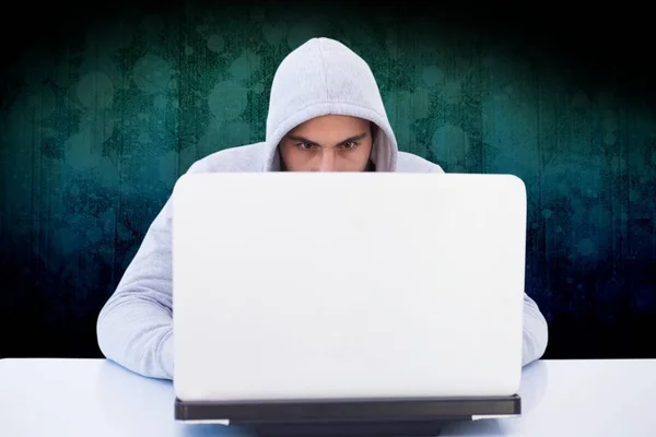Hacker používající svůj notebook před tmavým pozadím — Stock fotografie