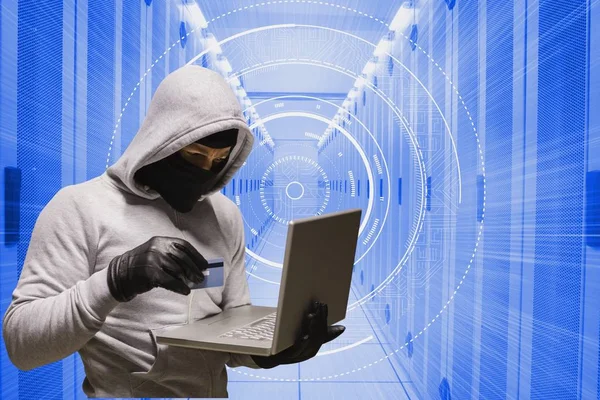 Cyber-Krimineller hält Kreditkarte und Laptop vor Datenbank-Hintergrund — Stockfoto