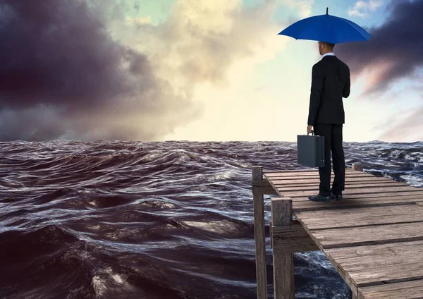 Achteraanzicht van zakenman holding blauwe paraplu met werkmap — Stockfoto