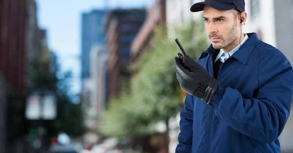Security guard met walkie talkie tegen wazig straat — Stockfoto