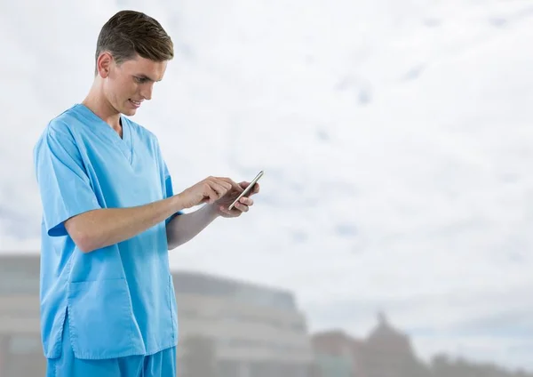 Doctor sosteniendo el teléfono con fondo exterior brillante — Foto de Stock