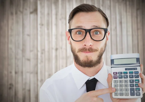 Hombre con calculadora contra panel de madera borrosa —  Fotos de Stock