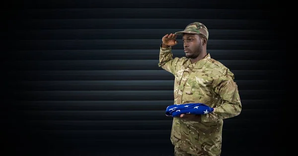 Soldaat die met de vlag van de Verenigde Staten in zijn hand. donkere achtergrond — Stockfoto