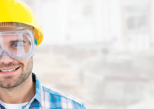 Trabajador de la construcción con gafas de protección ocular en frente del sitio de construcción —  Fotos de Stock