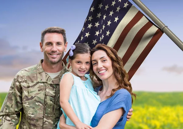 Soldado con familia frente a la bandera de EE.UU. en el campo — Foto de Stock