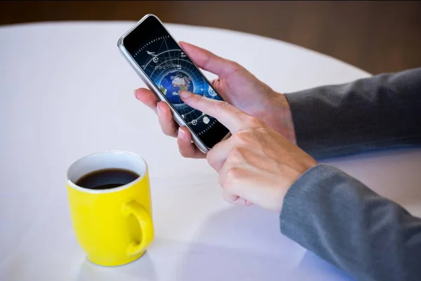 책상 배경 커피 한 잔 옆의 스마트폰 화면을 보여주는 손 — 스톡 사진