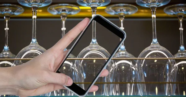 Mano fotografare a testa in giù bicchieri di vino attraverso smart phone — Foto Stock