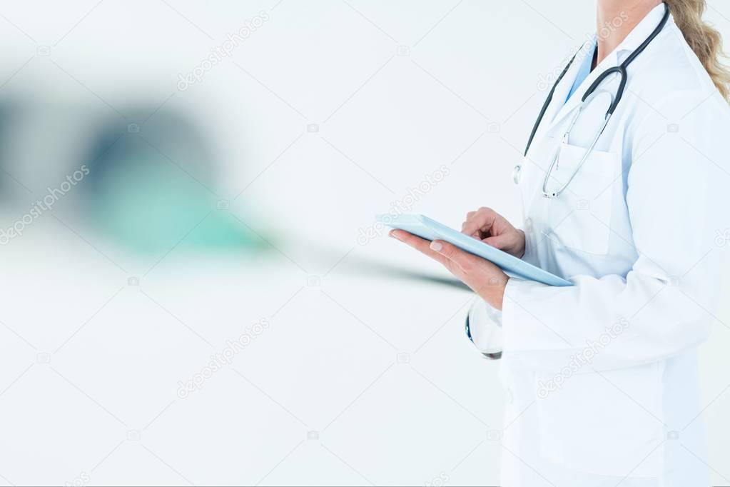 doctor woman is holding a tablet computer against white background 