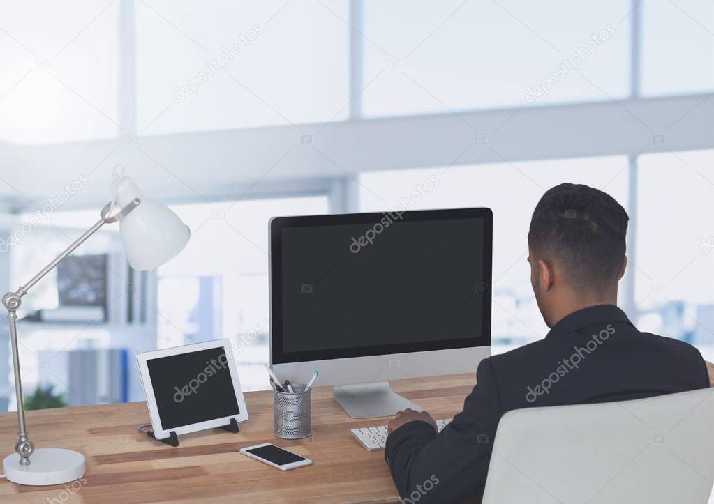Businessman on computer in large bright office