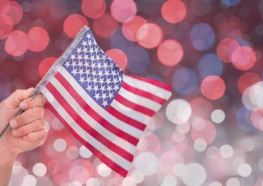 Parlak ışık bokeh arka plan ile Amerikan bayrağı tutan el