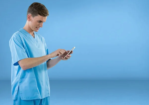 Médico con un teléfono móvil sobre fondo azul — Foto de Stock