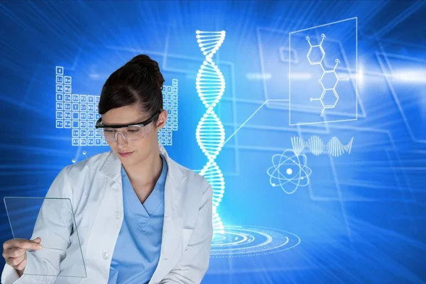 Modelos médicos usando óculos de segurança olhando para a corrediça do microscópio contra o fundo gráfico azul — Fotografia de Stock