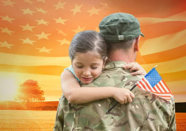 Soldado abrazando hija en el campo con bandera de EE.UU. — Foto de Stock