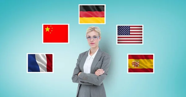 Portrait of businesswoman with arms crossed standing by flags against blue background — Stock Photo, Image