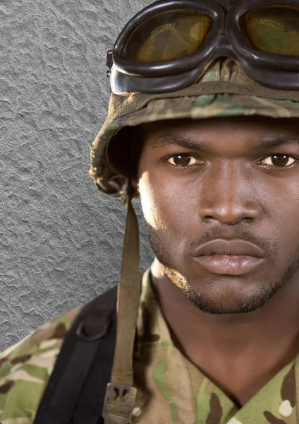 De voorgrond van soldaat met helm (met bril) op zoek naar ons. Betonnen wand achter — Stockfoto