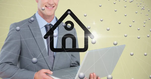 Бізнесмен тримає ноутбук з домашнім символом і з'єднувальними точками — стокове фото