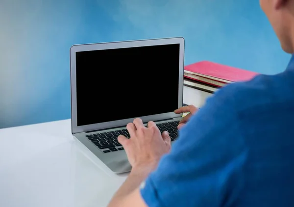 青色の背景と机とノート パソコンを使用している人 — ストック写真