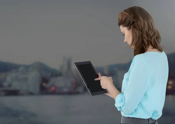Affärskvinna innehav tablett med avlägsen grå staden bakgrund — Stockfoto