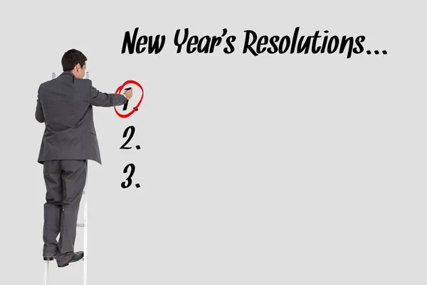 Business man is surrounding a response of new year's resolutions question against grey background — Stock Photo, Image