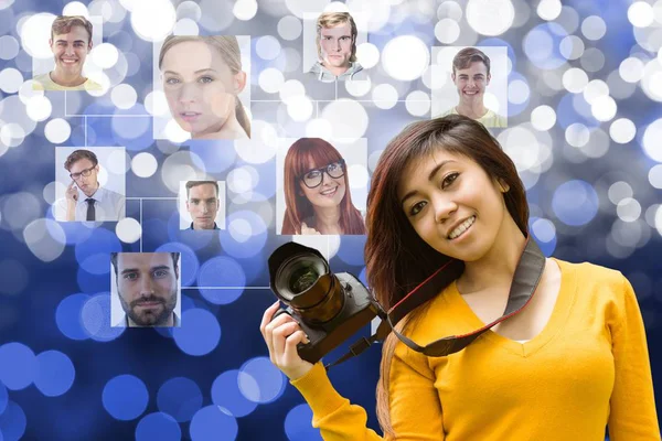 Young woman holding a camera in front of organization chart — Stock Photo, Image