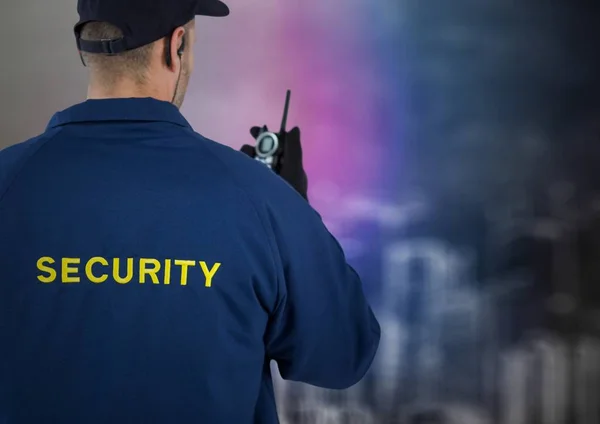 Baksidan av säkerhetsvakt med walkie talkie mot suddiga vägg med byggnaden skiss — Stockfoto