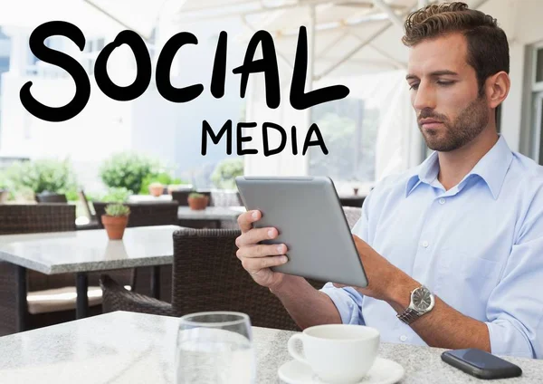 Texto de mídia social contra homem no café com tablet — Fotografia de Stock