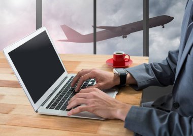 Havaalanında uçak vasıl pencere ile dizüstü bilgisayar kullanarak iş adamı