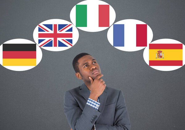main language flags around businessman thinking. Dark grey background