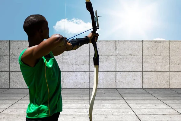 Archer tire une flèche depuis un toit sur fond de ciel — Photo