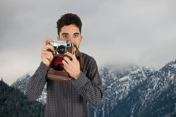 Uomo occasionale che scatta una foto di fronte a montagne innevate — Foto Stock