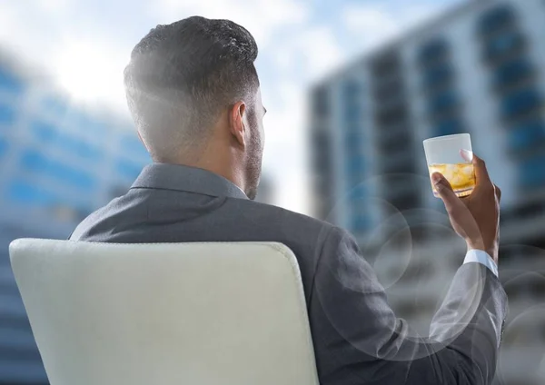 Achterkant zakenman drinken en kijken wazig gebouwen — Stockfoto