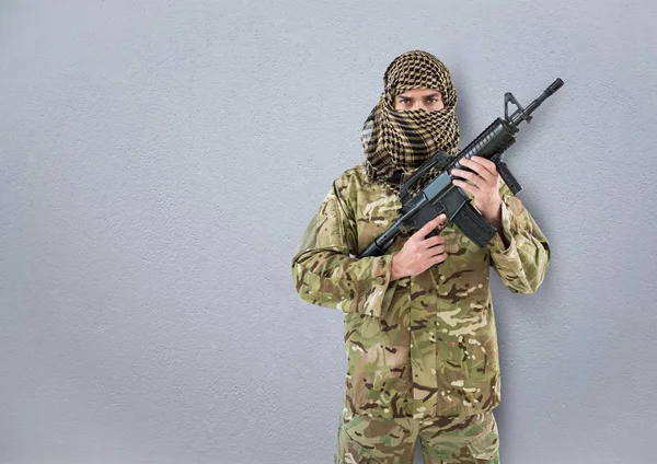 Żołnierz z zakrytej twarzy i broń w rękach. betonowe ściany — Zdjęcie stockowe