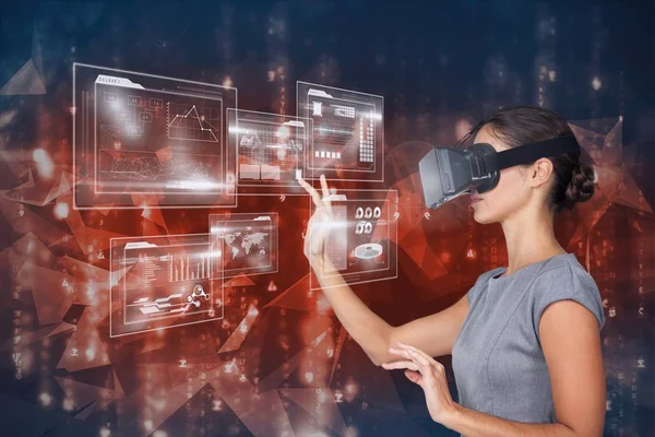 Geschäftsfrau mit Virtual-Reality-Headset rührt Grafik vor abstraktem Hintergrund an — Stockfoto