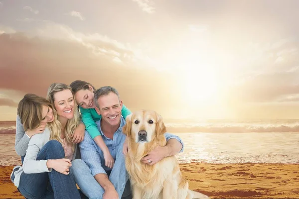 Lachende gezin met een hond op het strand — Stockfoto