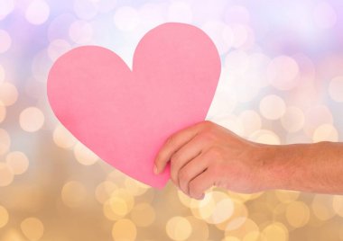 Parlak ışık bokeh arka plan ile kalp kesip el holding