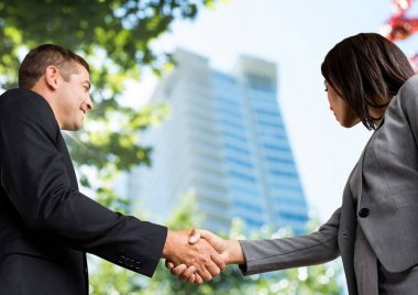 iş erkek ve kadın el sıkışma. Gökyüzü görünümü. Şehir ofis binası önünde