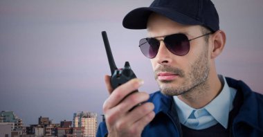 Security guard with walkie talkie against skyline and purple sky clipart