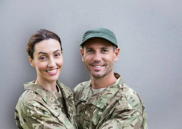 soldiers couple smiling. concrete wall