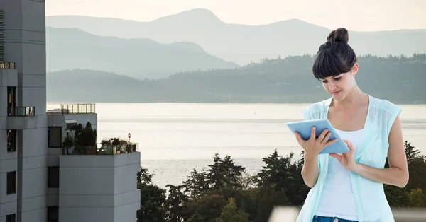 山に対して建物に立っている間デジタル タブレットを見て美しい女性 — ストック写真