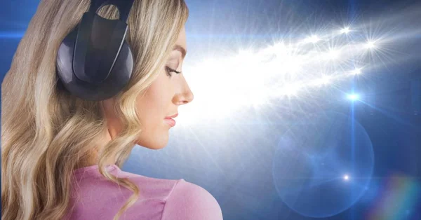 Szőke hajú lány listenning zene hát-hoz-a fénykép-val kék háttér fejhallgató — Stock Fotó