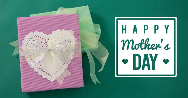 Regalo rosa con un corazón blanco para el día de la madre sobre fondo verde —  Fotos de Stock