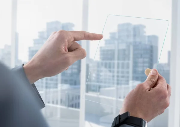 Geschäftsmann hält Glastablette gegen Fenster — Stockfoto