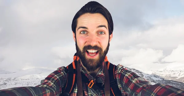 Hipster biorąc selfie stojąc na górze przeciwko niebo — Zdjęcie stockowe